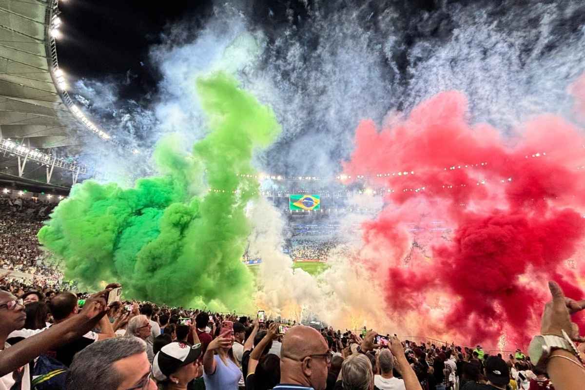 Torcida do Fluminense na arquibancada do Maracanã com fumaça verde e grená e fogos de artifício