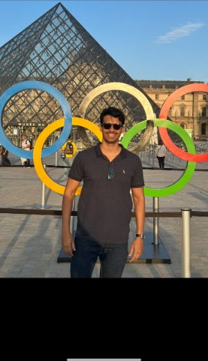 Enzo Marino junto aos anéis olímpicos em frente ao Museu do Louvre, durante os Jogos Olímpicos de Paris 2024